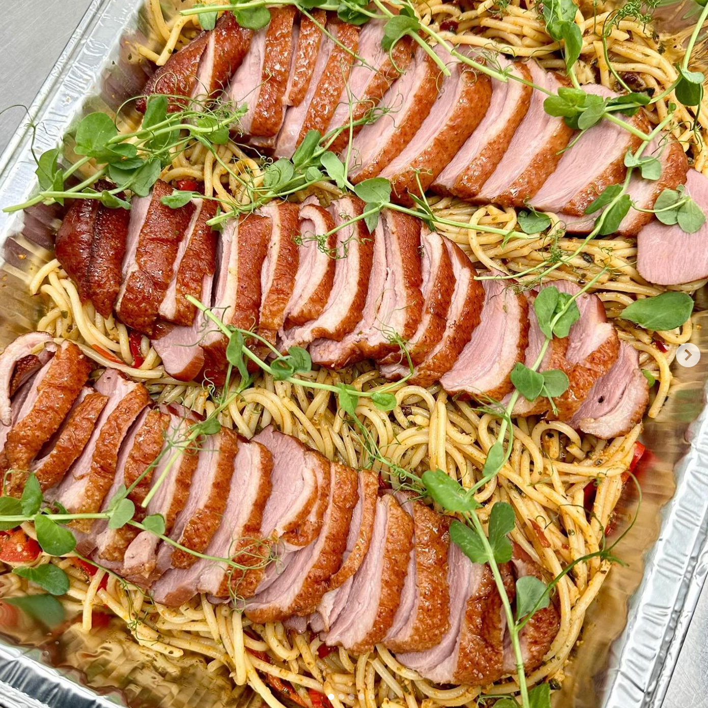 Tray of pasta with sliced roasted duck breast